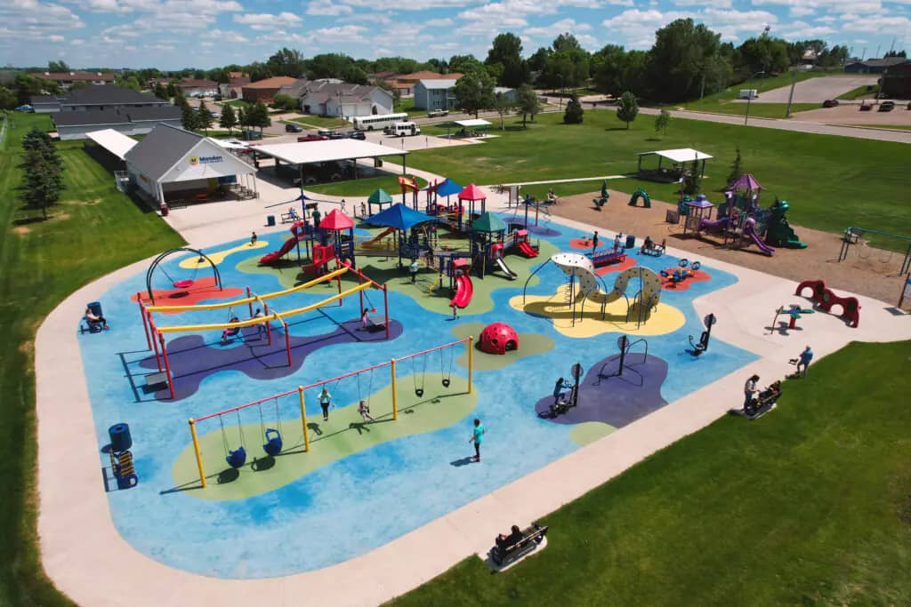 Universal Playground in Mandan with inclusive play structures and open rubber-surfaced layout