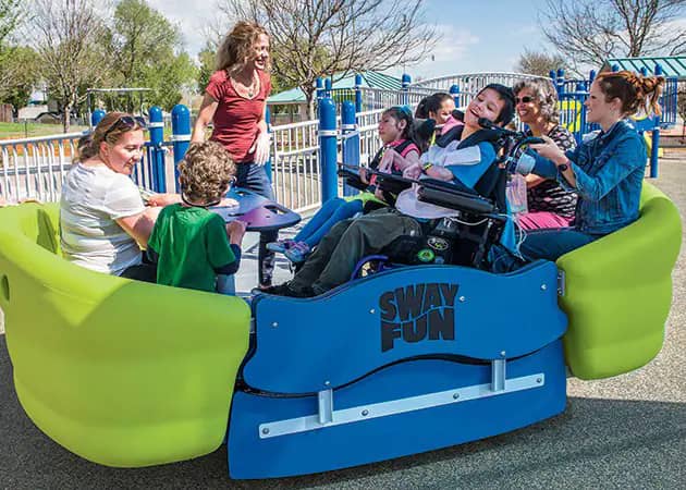 Children with and without disabilities playing on a glider