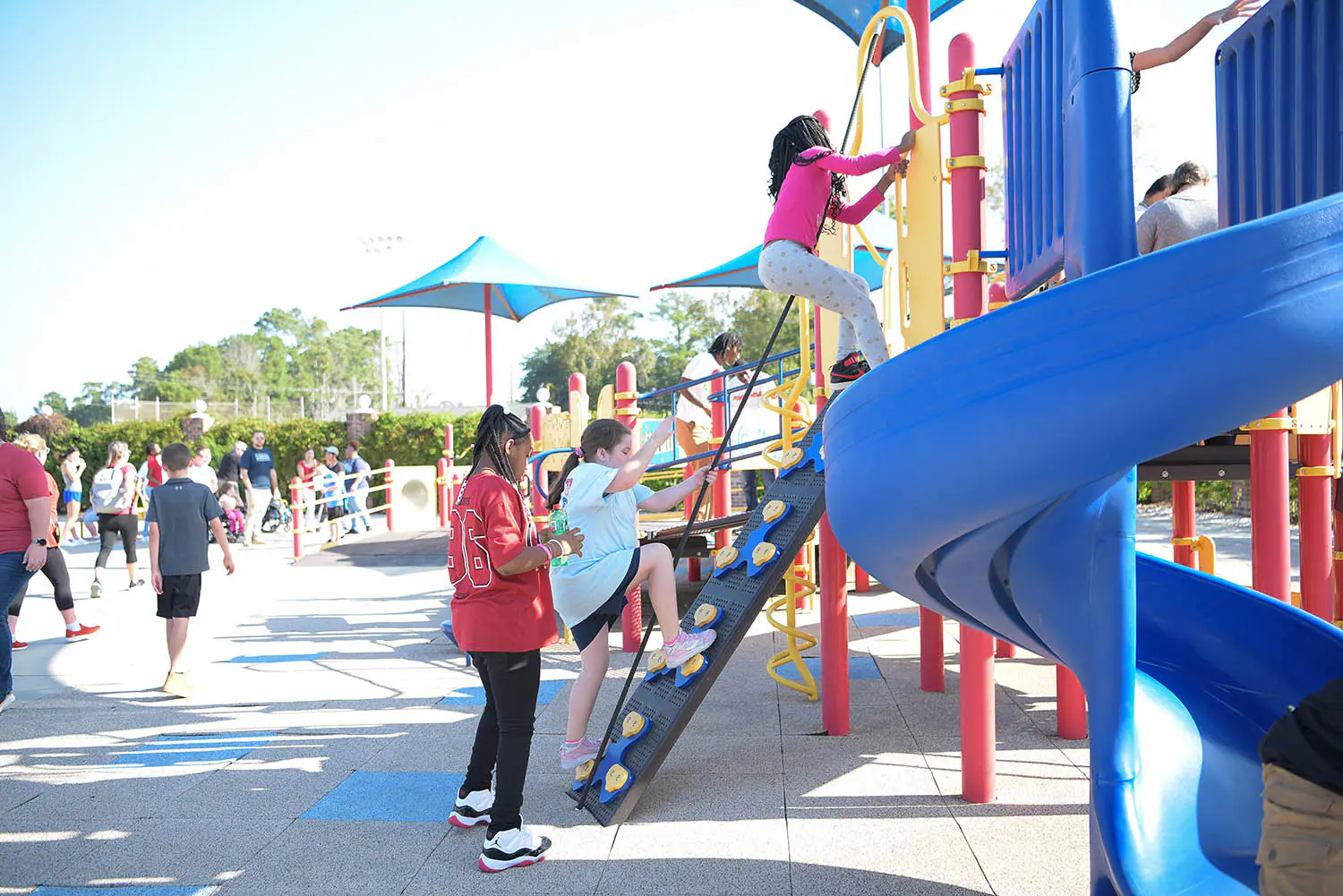 Students climbing on All-Star Park play equipment