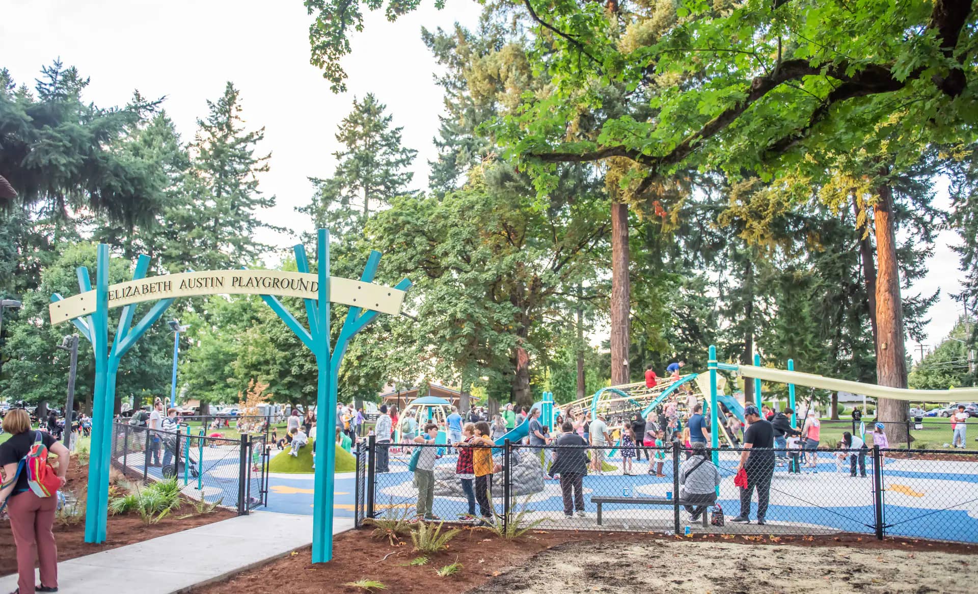 Children playing on the fully fenced inclusive Elizabeth Austin Playground at Fruit Valley Park in Vancouver.