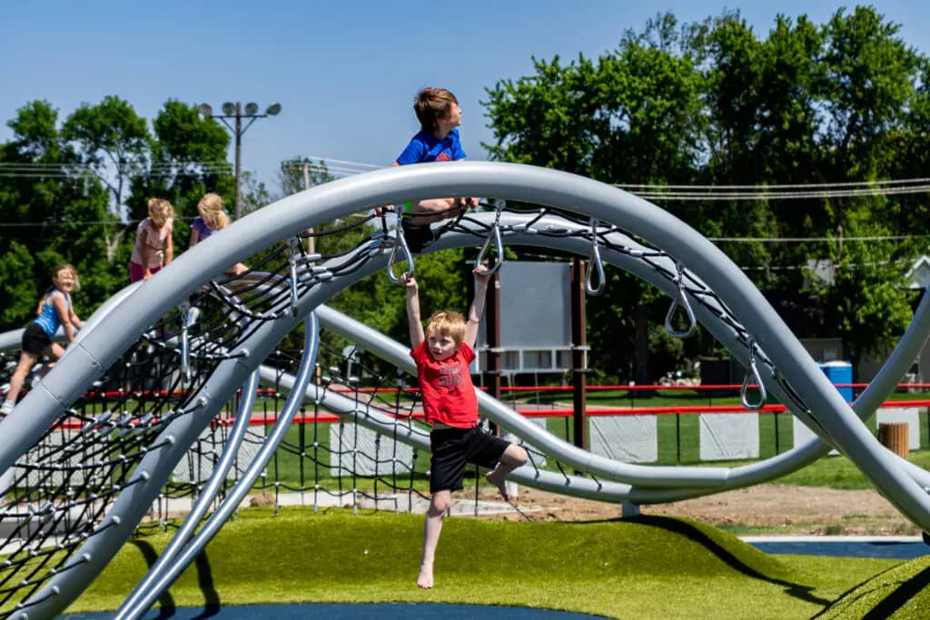 Children playing on the inclusive playground at Aspen Seemann Memorial Park in Spirit Lake