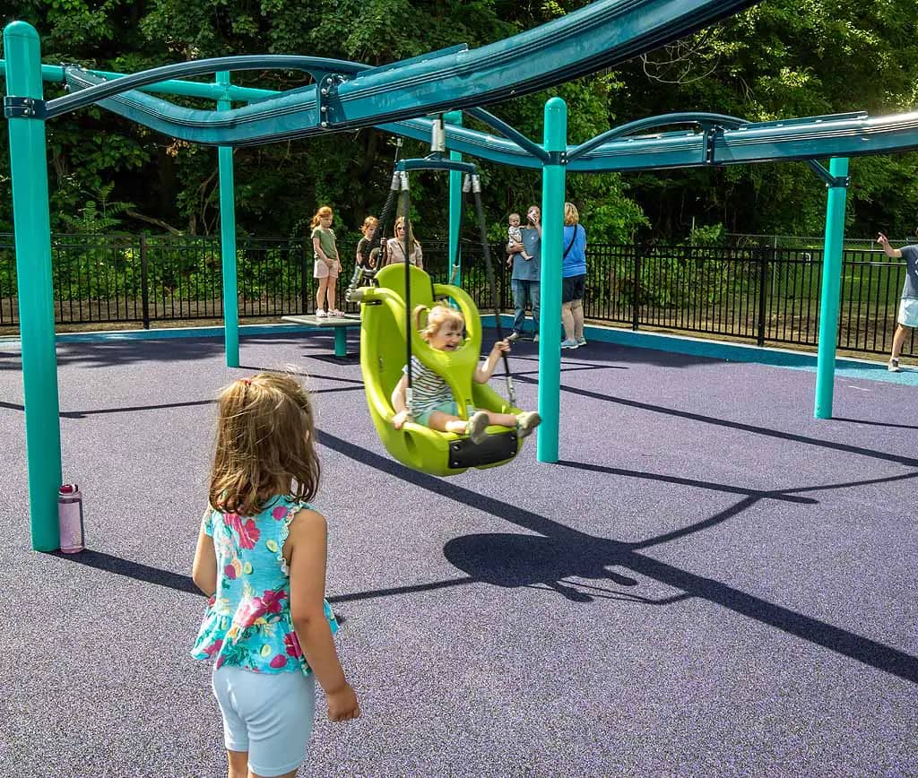 Children using the double zipline at Kaleidoscope Playground in Kiwanis Park