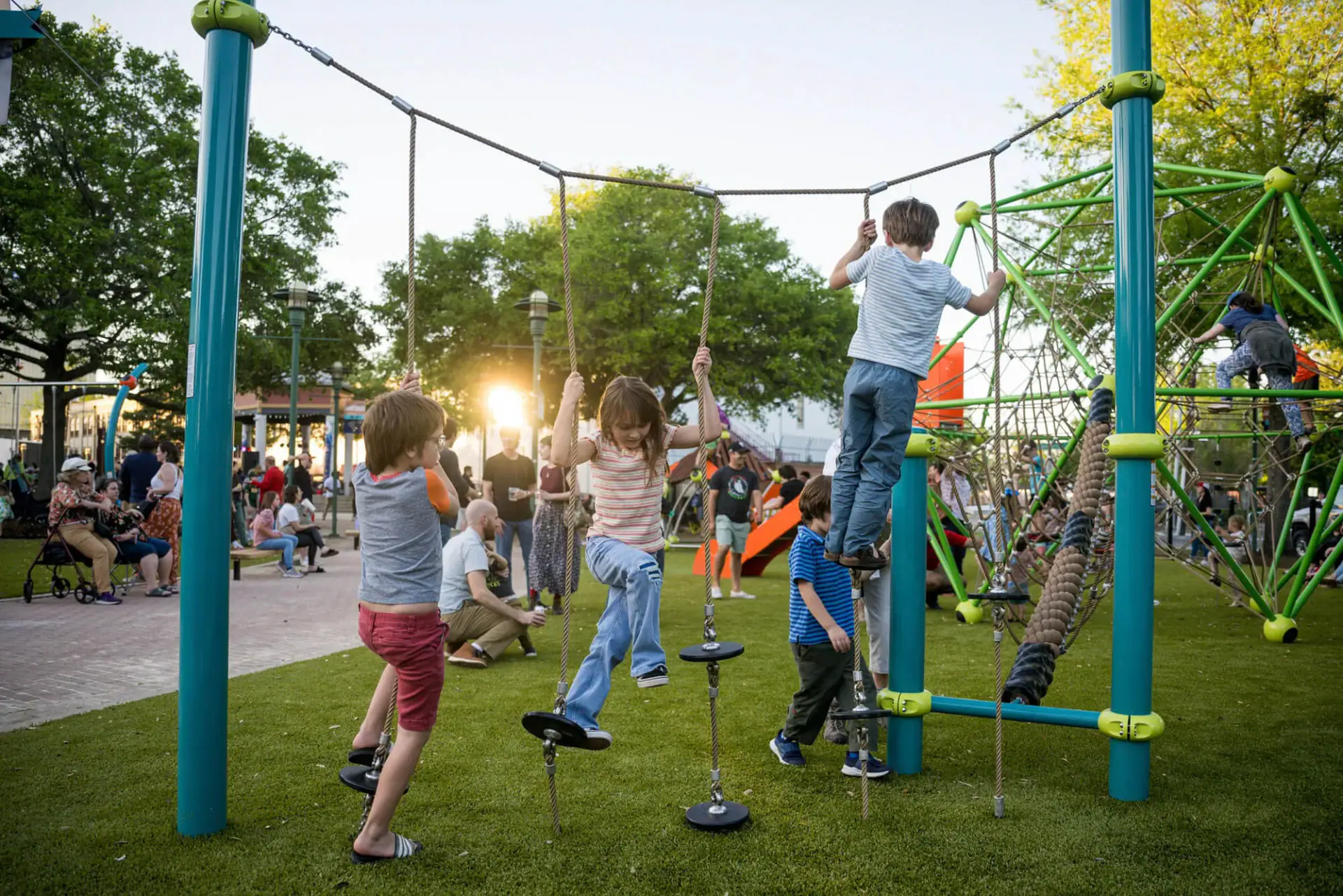 Children playing on rope structures at The Playground in Parc Sans Souci