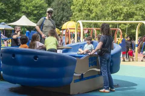 Wide view of Clemyjontri Park's colorful accessible playground in Mc Lean